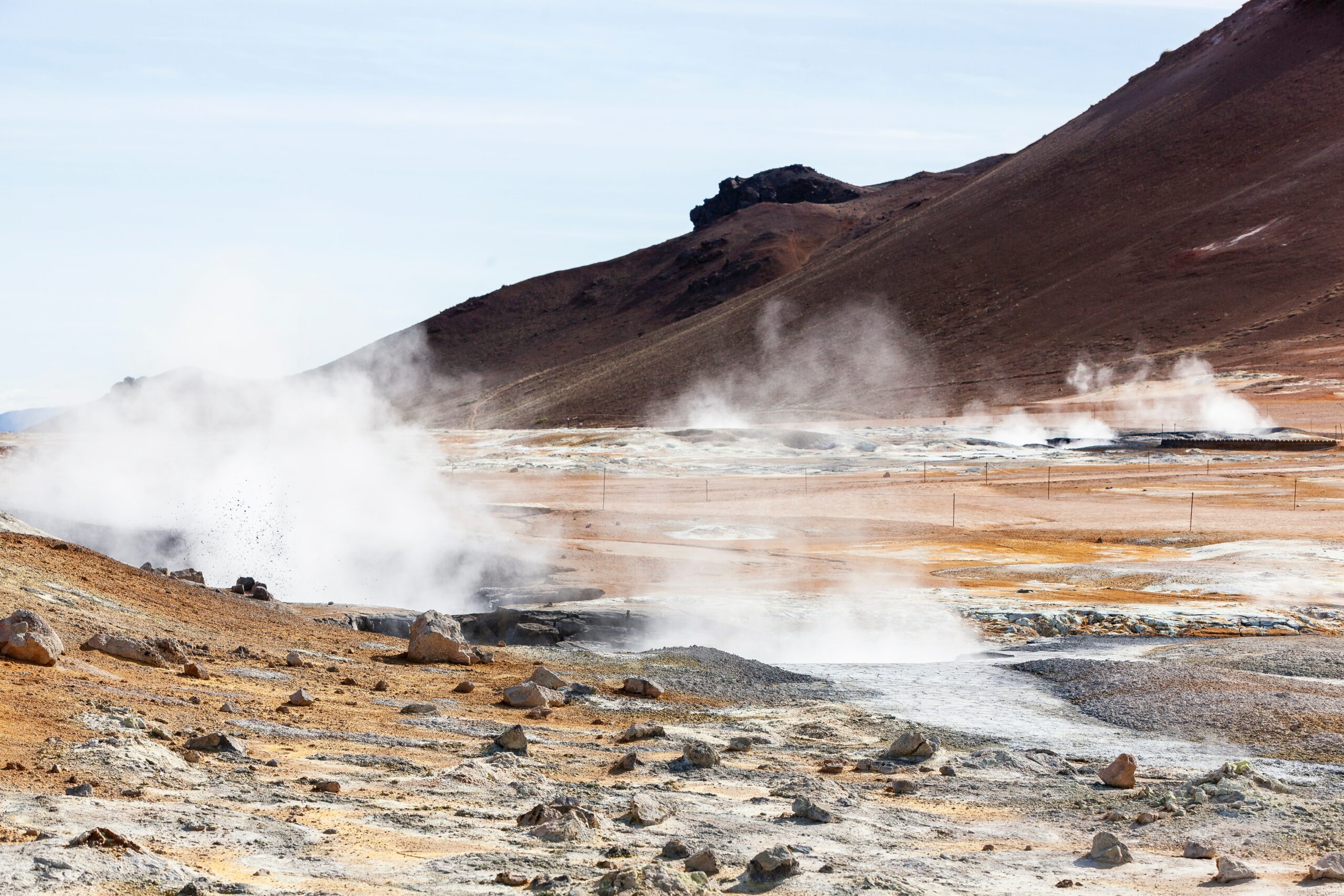 geothermal smoke coming from the ground against a mountain in Iceland